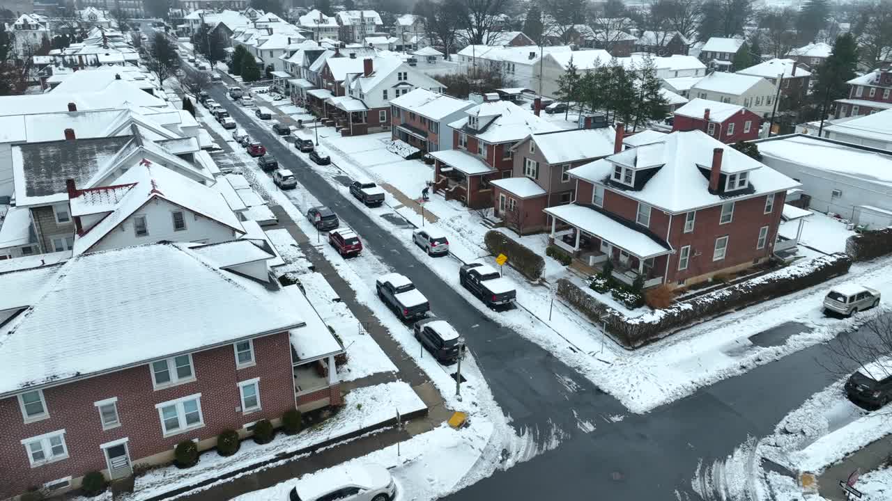 美国郊区街道的鸟瞰图。屋顶上的冬日雪。灰色，多云的天空。视频素材