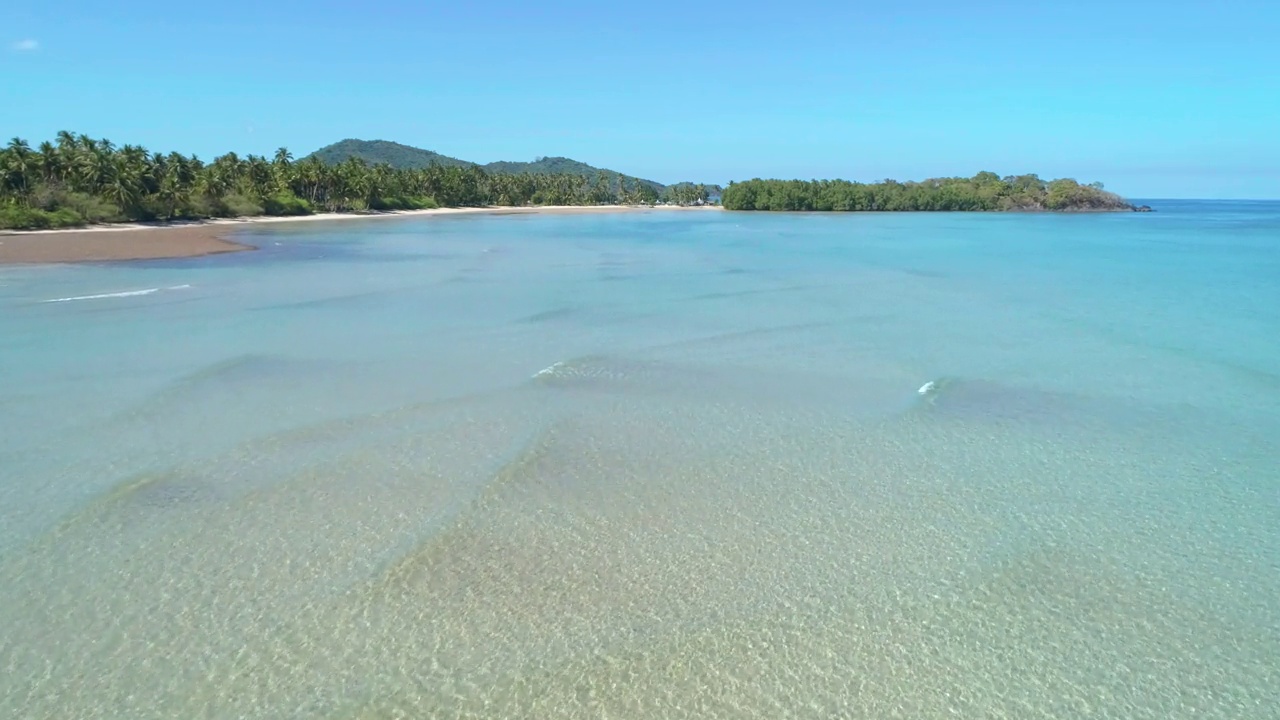 热带沙滩鸟瞰图在海湾与蓝色的水。海景，有大海，沙滩，棕榈树。天堂岛的俯视图。暑假和旅游度假的概念。视频素材