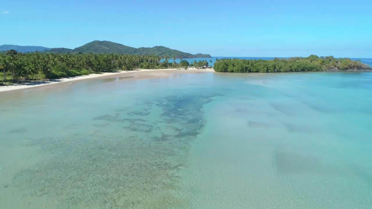 热带沙滩鸟瞰图在海湾与蓝色的水。海景，有大海，沙滩，棕榈树。天堂岛的俯视图。暑假和旅游度假的概念。视频素材