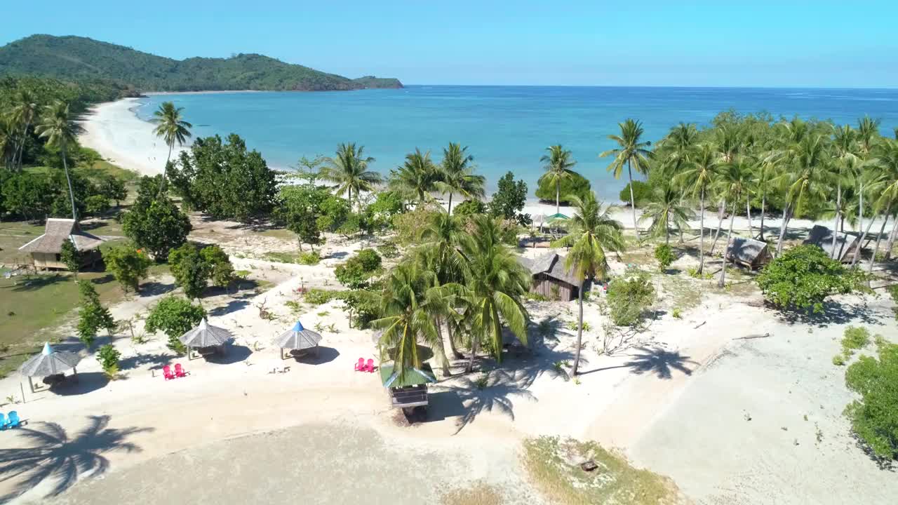 热带沙滩鸟瞰图在海湾与蓝色的水。海景，有大海，沙滩，棕榈树。天堂岛的俯视图。暑假和旅游度假的概念。视频素材