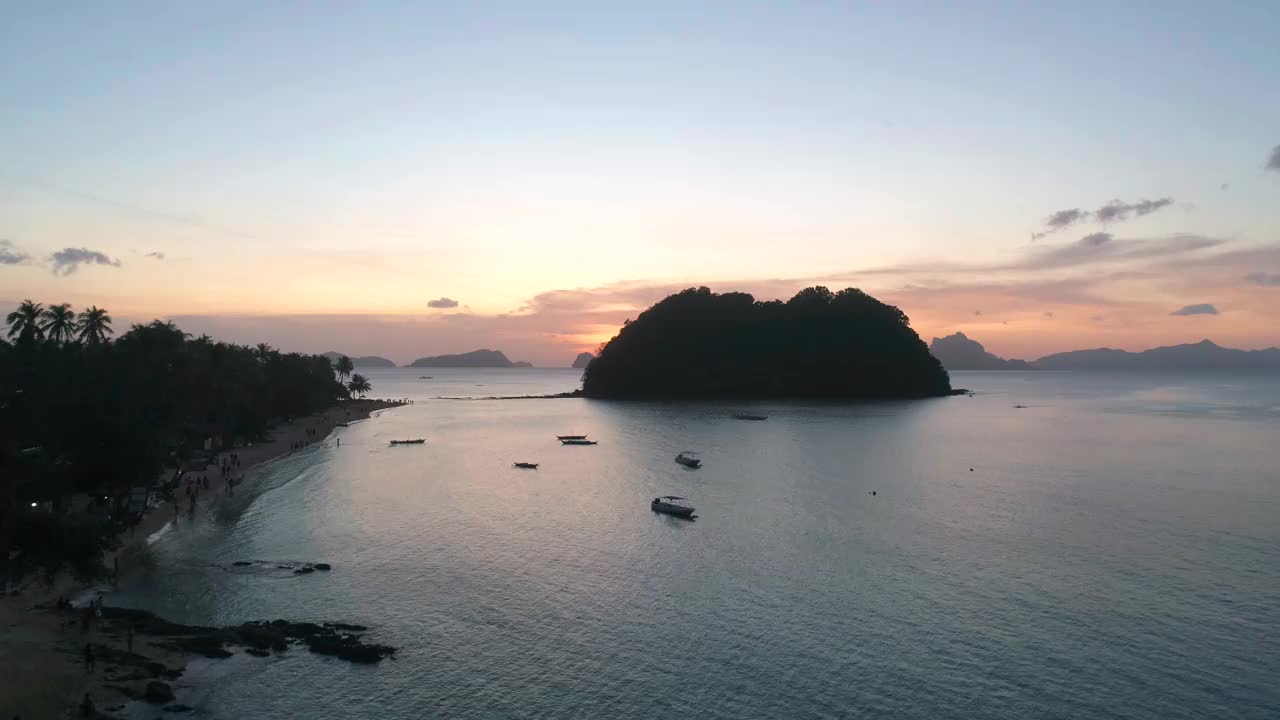 日落时从热带岛屿上空鸟瞰。视频素材