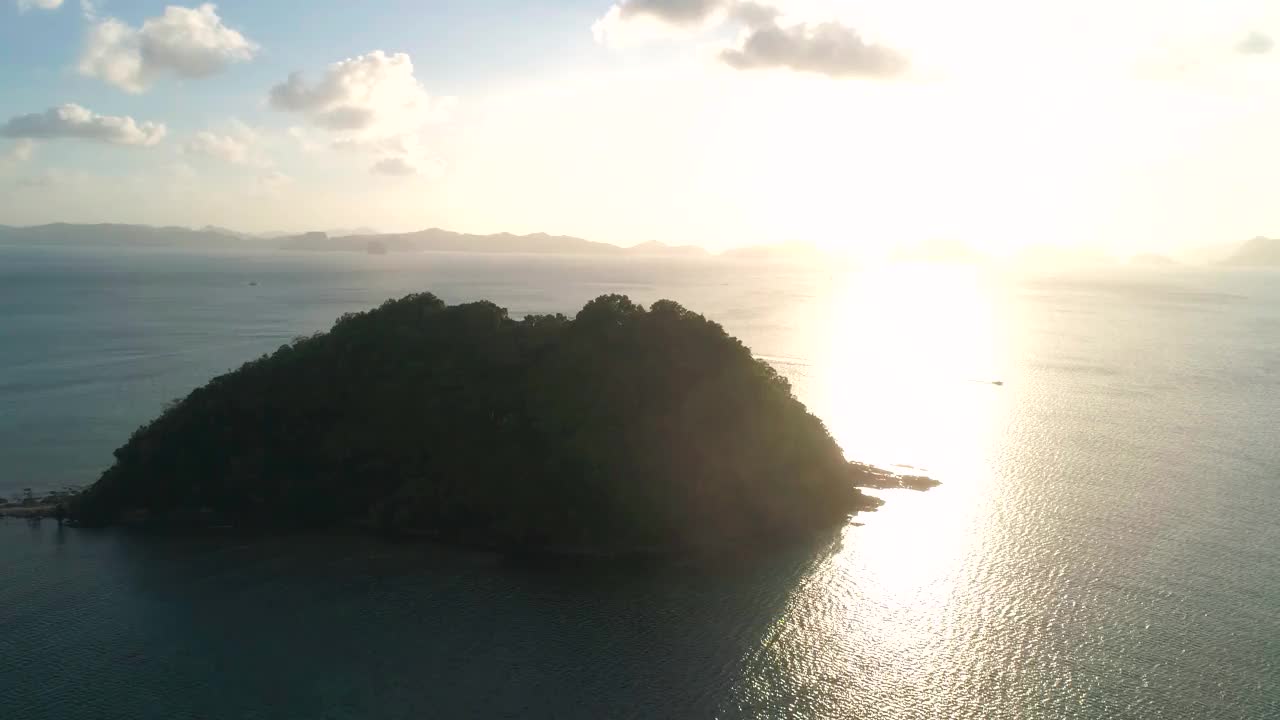 日落时从热带岛屿上空鸟瞰。视频素材