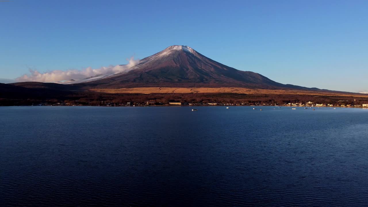 山中湖平静的湖水与雄伟的富士山在背景下，晴朗的天空视频素材