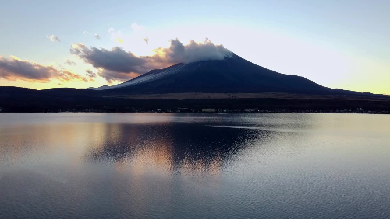 富士山的夕阳映照在平静的湖水中，云朵飘过视频素材