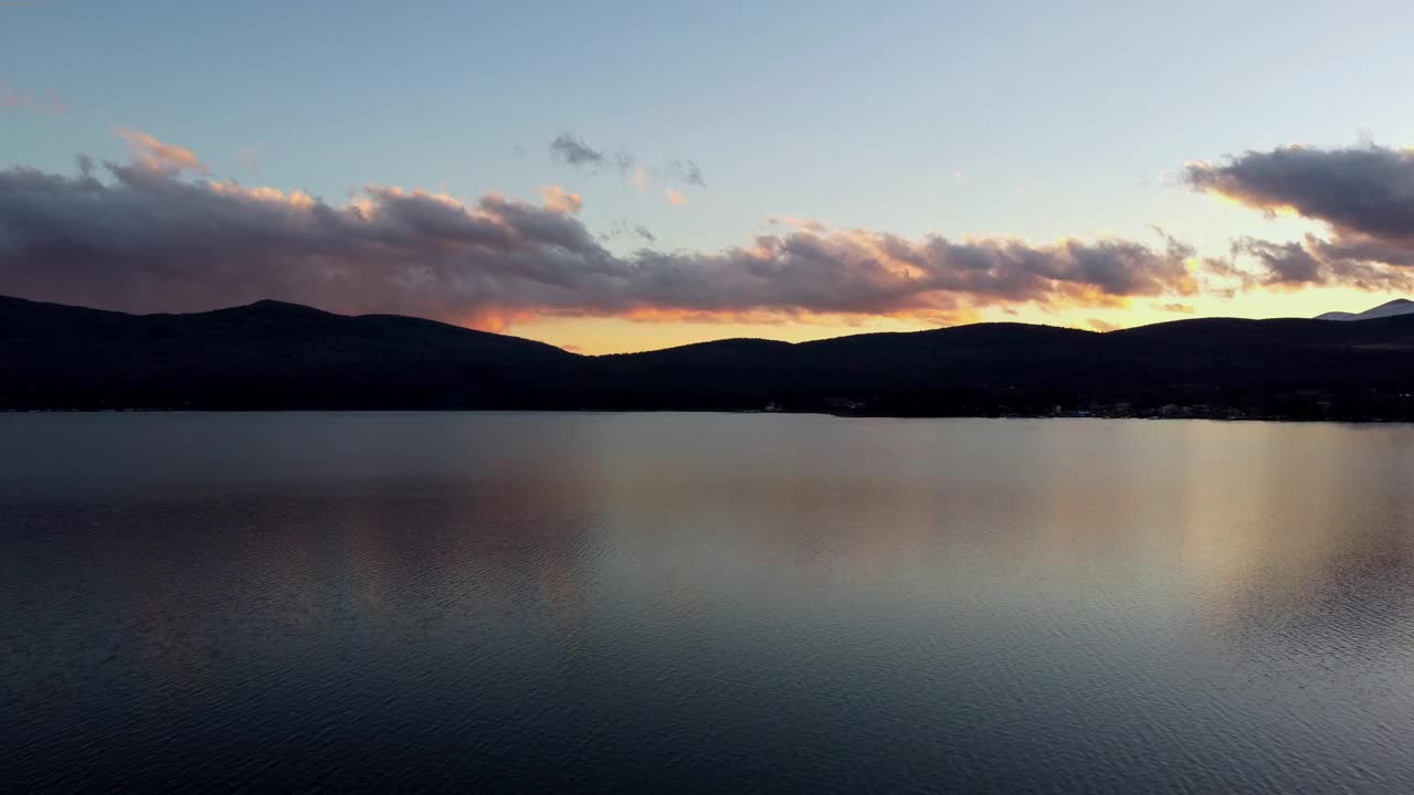 日落在平静的湖面上，山和云的剪影反射在水面上，鸟瞰图视频素材