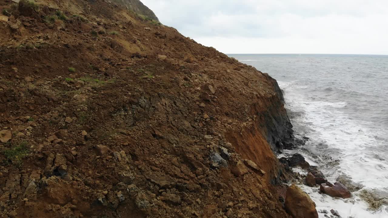 Seatown海滩沿岸大悬崖瀑布的侧视图。空中上升投篮视频素材