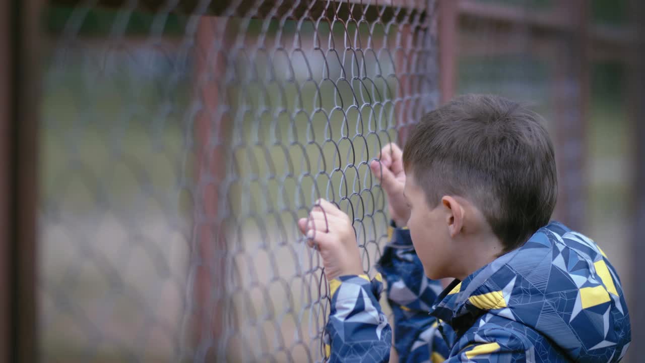 孤独与恢复力:悲伤的男孩在街上的烟斗里寻求庇护，面对绝望的处境视频素材