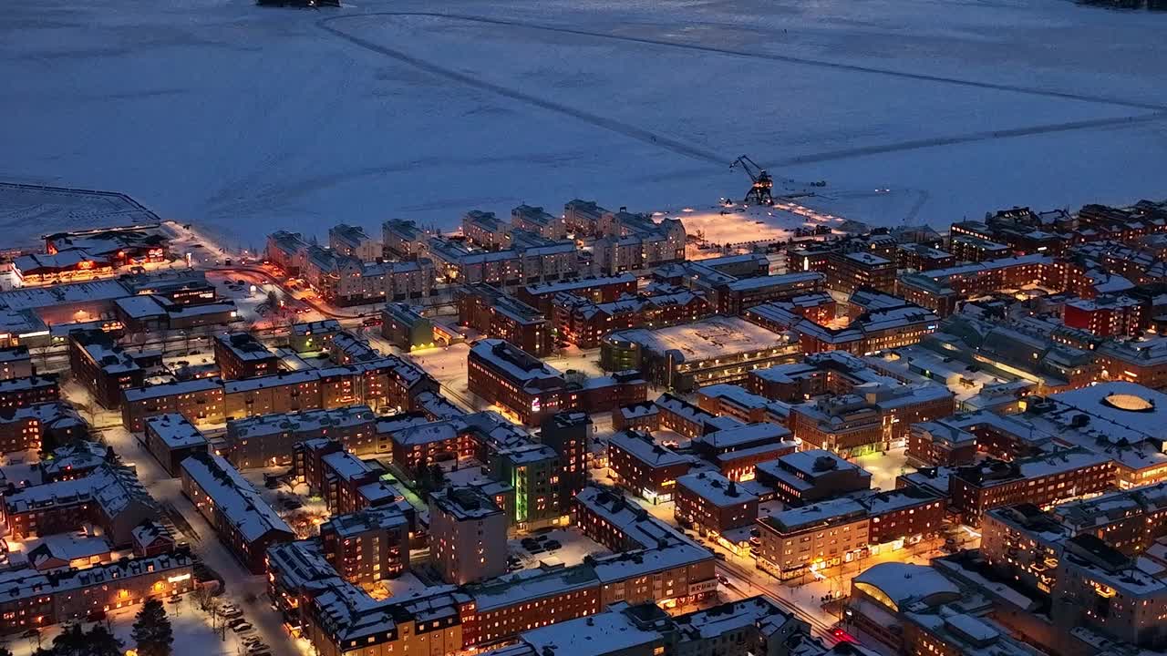 暮色降临在白雪覆盖的卢勒堡城市景观上，发光的街灯，鸟瞰视频素材