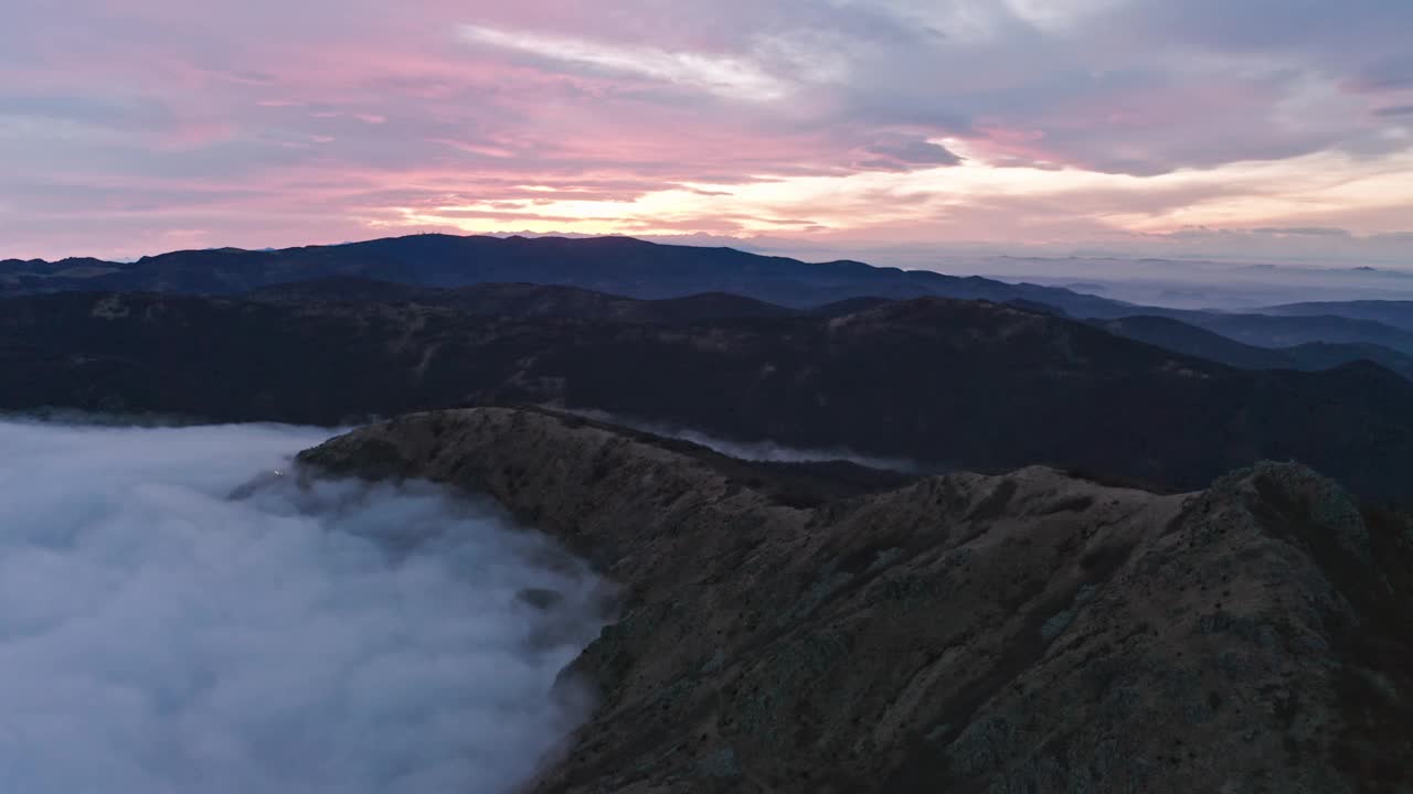 云雾缭绕的群山破晓，云雾在山谷中沉淀，宁静的航拍画面视频素材