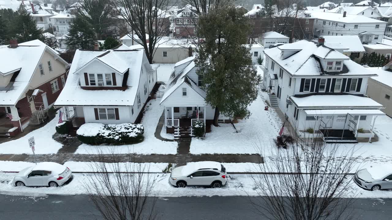 美国居民区冬天下雪。在街上停车。美国国旗。美国小镇郊区的房子。空中卡车拍摄。视频素材