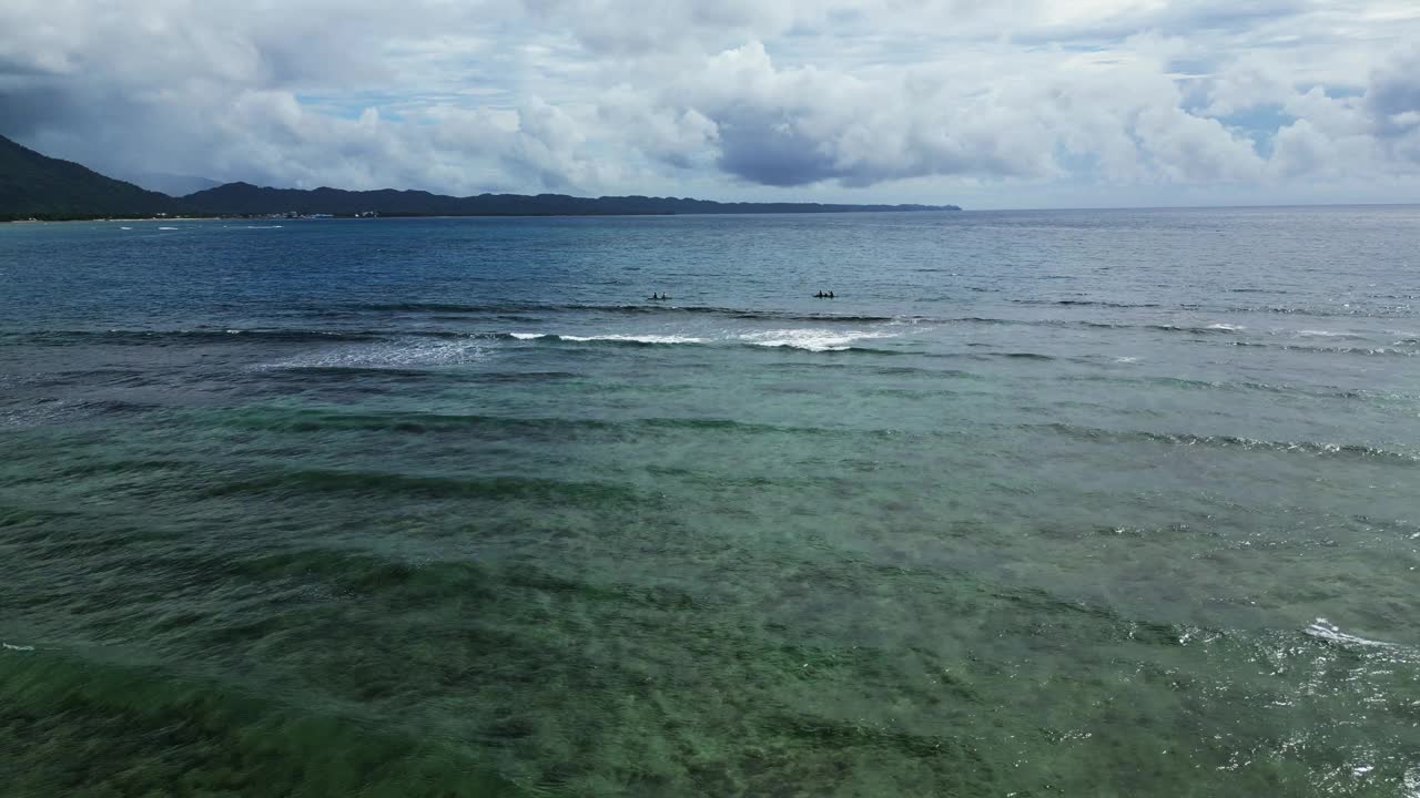 菲律宾卡坦多内斯，多云的天空，阿戈霍圣安德烈斯的海岸景观，清澈的海水和冲浪者视频素材