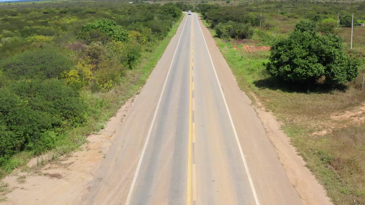 一辆车在白天行驶在一条双车道的乡村公路上视频素材