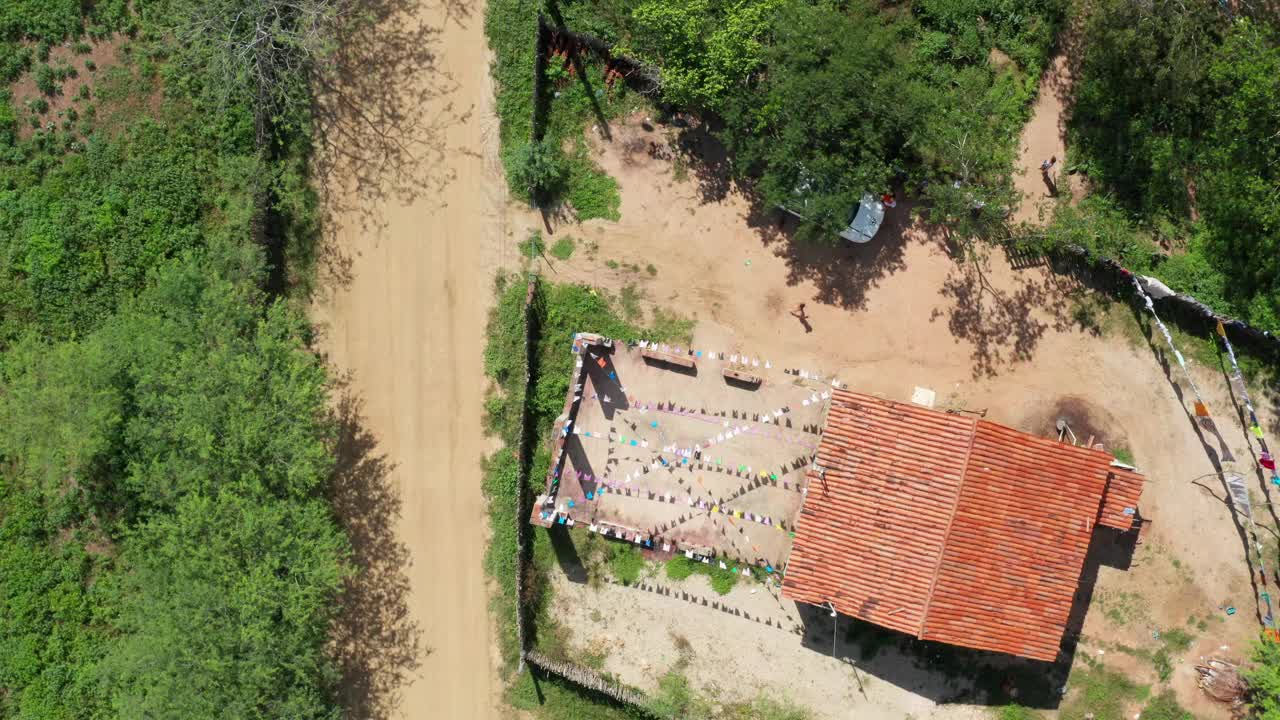 在一个阳光明媚的日子里，鸟瞰乡村土路和建筑大院视频素材