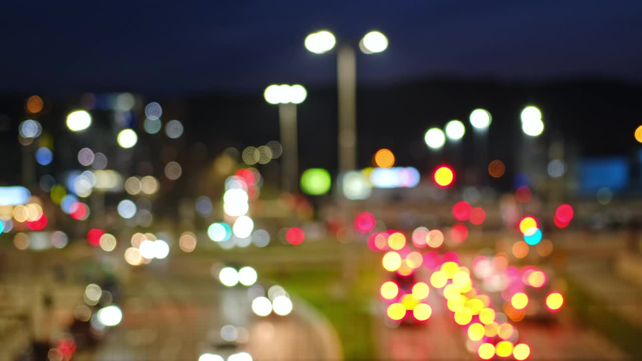 模糊的夜晚城市街道与路灯交通灯和汽车前灯尾灯视频素材