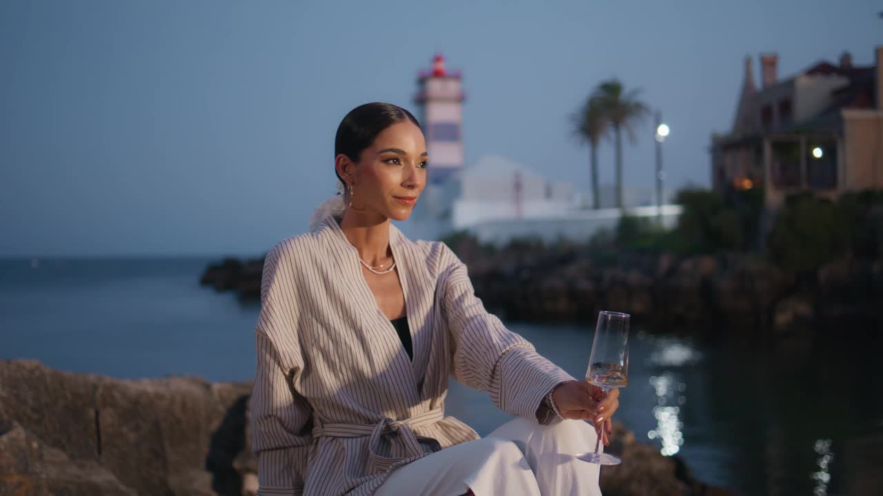 梦幻的女孩在海滨的黄昏放松酒杯。放松的女人休息视频素材