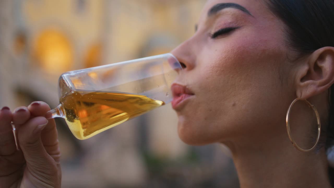 特写:女人用玻璃杯喝梅洛酒。肖像女孩喜欢喝白葡萄酒视频素材