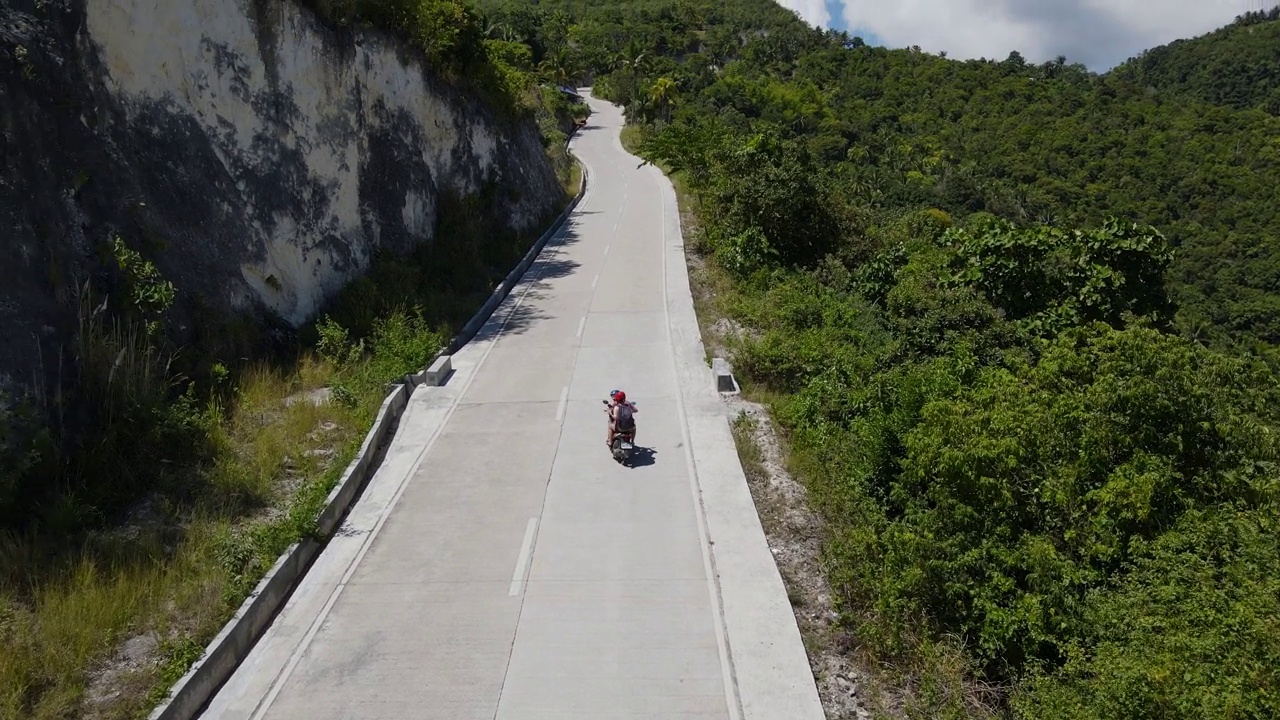 航拍的摩托车骑在风景秀丽的道路在宿雾岛白天视频素材