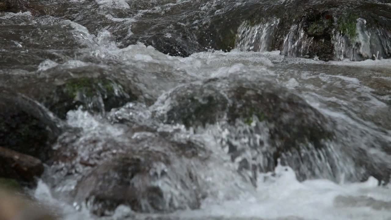 在石头之间的山河中流动的新鲜和干净的水的细节视频下载