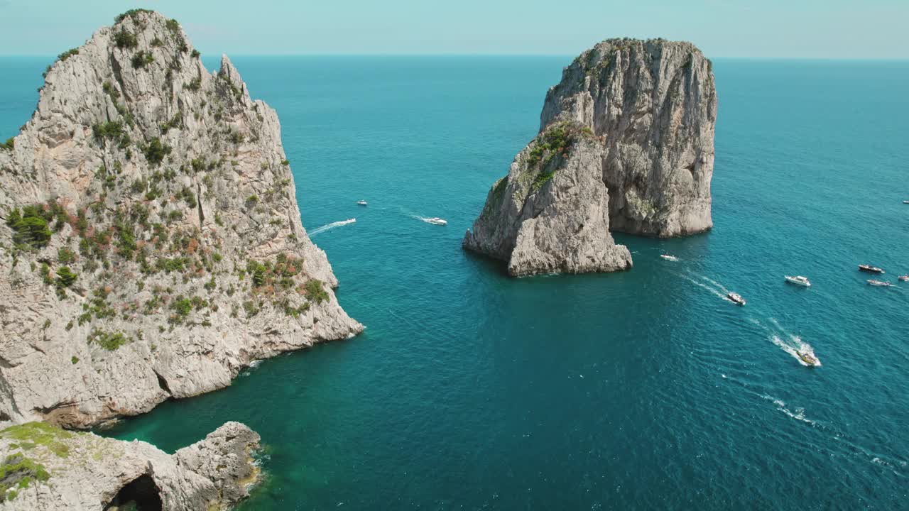 宁静的海景展现在眼前。宁静的大海映衬着清澈的天空，卡普里岛海岸峭壁和船只的自然壮丽。视频素材