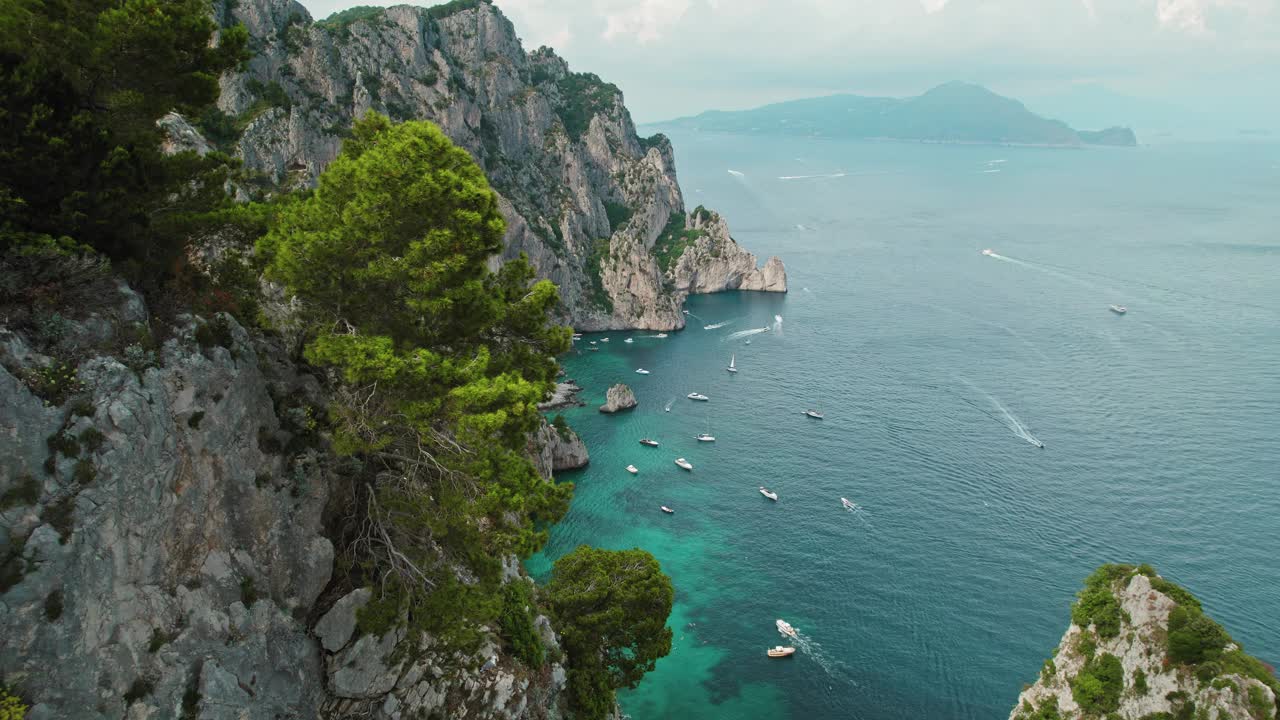 郁郁葱葱的海岸线上有船只和突出的岩石。意大利夏季海景鸟瞰图。视频素材