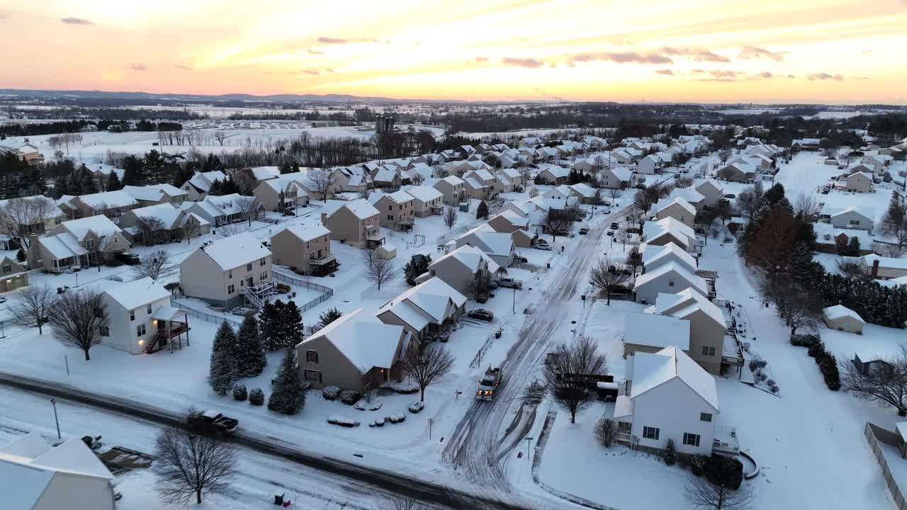 金色夕阳下的现代美国社区，白雪覆盖的房屋和正在开发的街道。视频素材