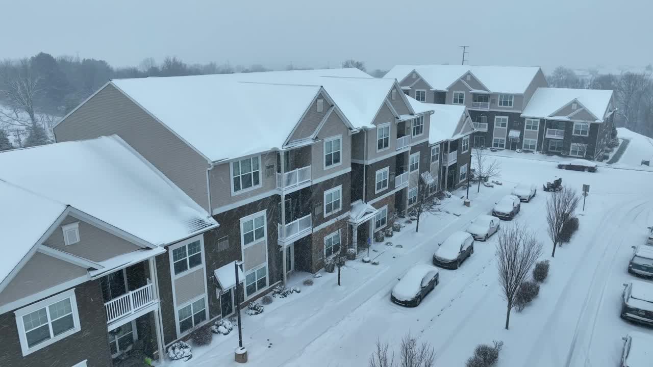 美国附近冬天下雪了。大雪覆盖了汽车和街道。空中着陆镜头。视频素材