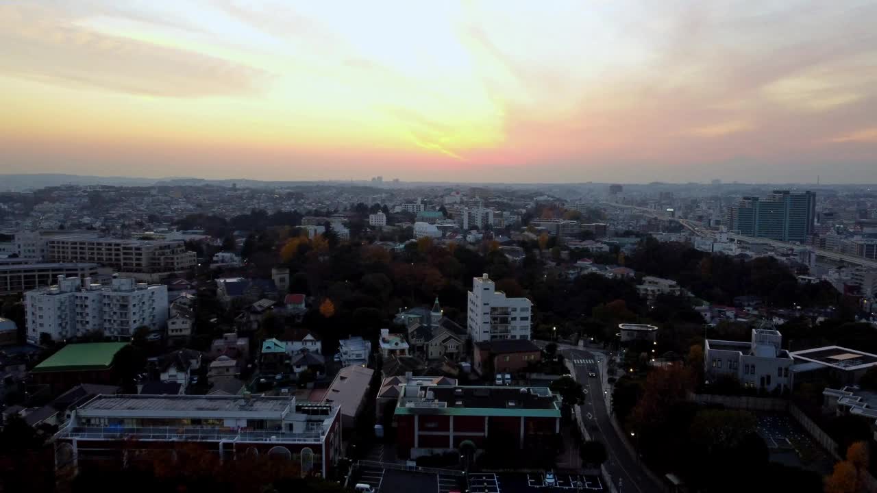 日落时的城市景观，生动的天空和城市轮廓，树木颜色暗示秋天，鸟瞰图视频素材