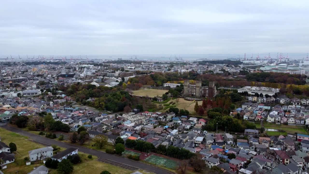 在一个阴天，有住宅区和绿地的城市景观，远处的起重机，鸟瞰图视频素材