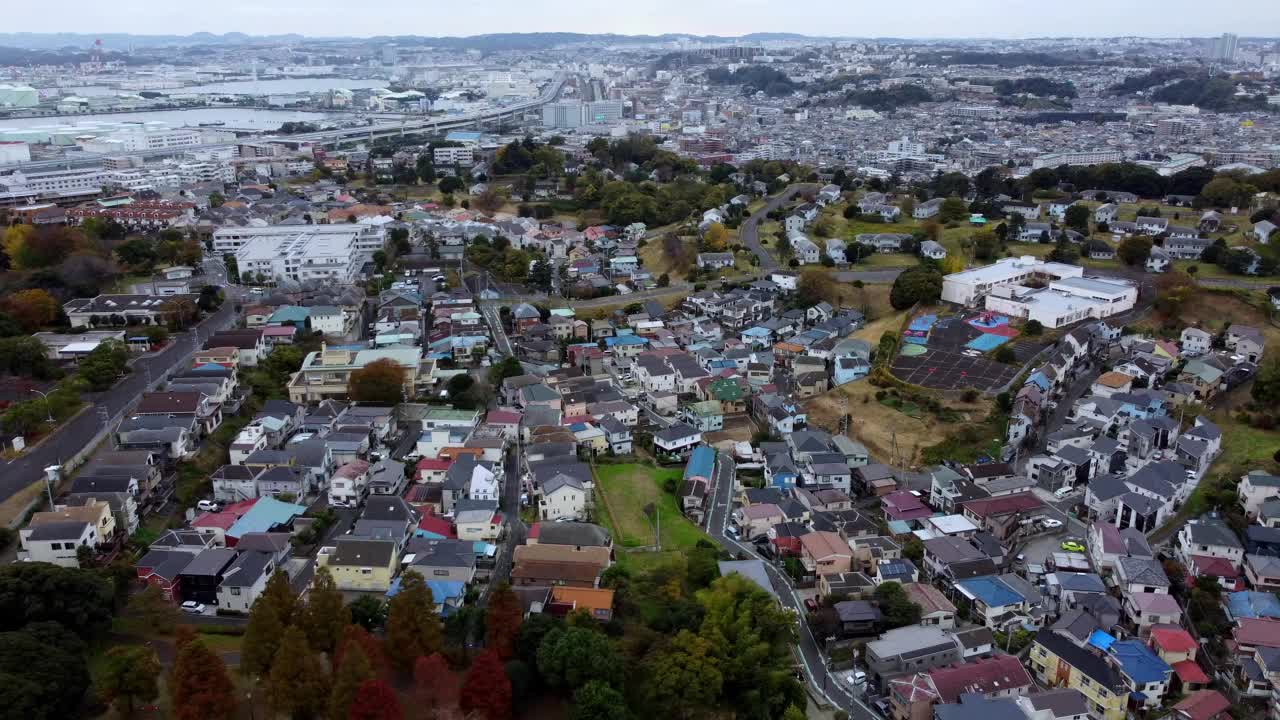 一个密集的，色彩丰富的住宅区，多云的天空背景，暗示秋天，鸟瞰图视频素材