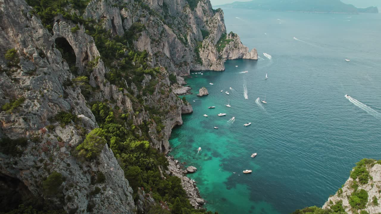 鸟瞰海景，船和戏剧性的岩石悬崖对着蓝色的海水。夏天的卡普里岛。视频素材