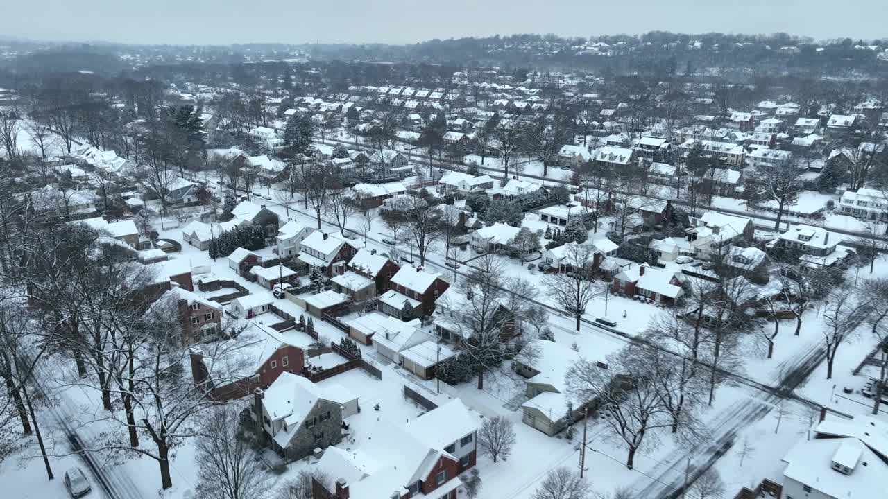 从空中俯瞰积雪覆盖的美国郊区。冬天里杂乱的社区。视频素材