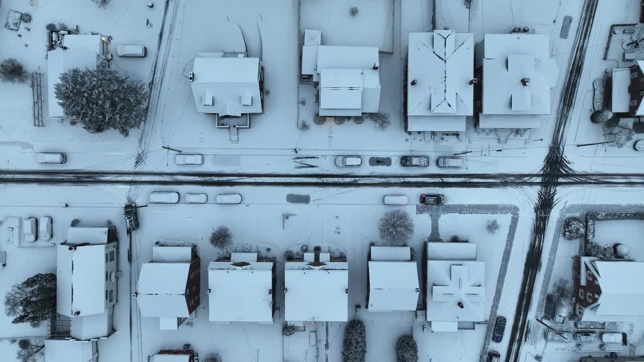 美国郊区冬季积雪覆盖的房屋。停放积雪覆盖的汽车。美国住宅区域上空的空中自上而下飞行。视频素材