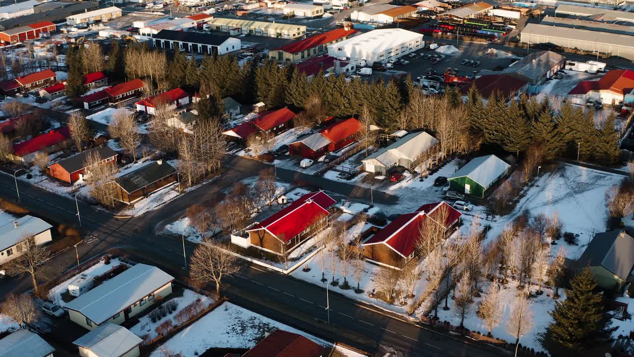 美丽的小住房区，冰岛岛上的房屋和建筑。圣诞节期间，落日的余晖和冬日的气息交织在一起。空中的鸟眼睛向后飞行。视频素材