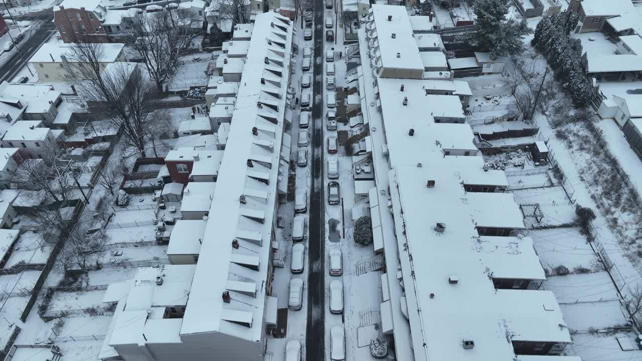 无人机鸟瞰美国附近的冬雪。狭窄的街道上停满了汽车。圣诞季节美丽的白色冬季城市。视频素材