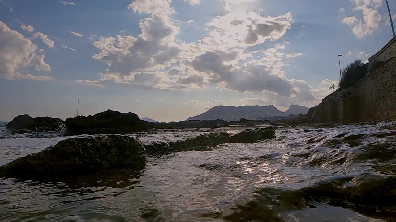 在地中海海岸线的水平面上，波浪在岩石间跳跃的缓慢动作视频下载