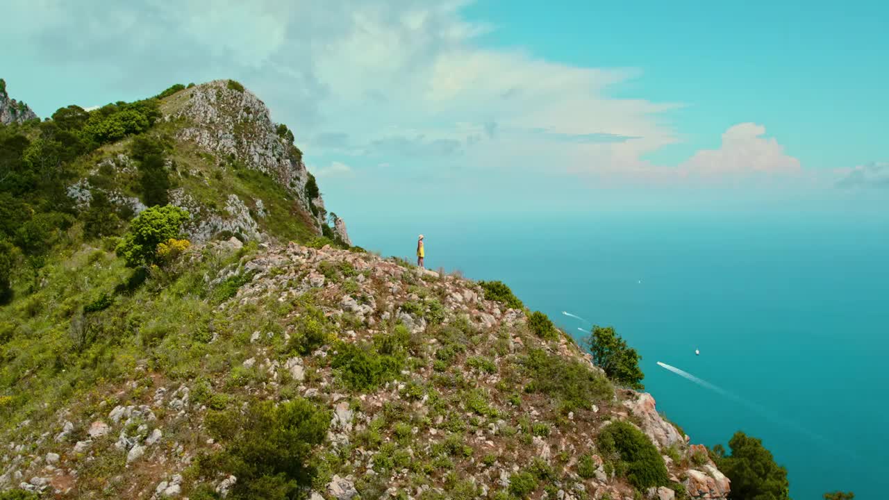 徒步旅行者到达卡普里岛的最高点，欣赏着广阔的海洋和岩石峭壁。去意大利度暑假。视频素材