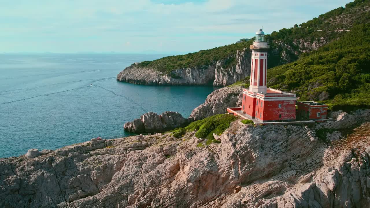 卡普里岛上标志性的红色灯塔Faro di Punta Carena的鸟瞰图，旁边是崎岖的悬崖。利多德尔法罗海滩俱乐部和餐厅在阿纳卡普里。视频素材