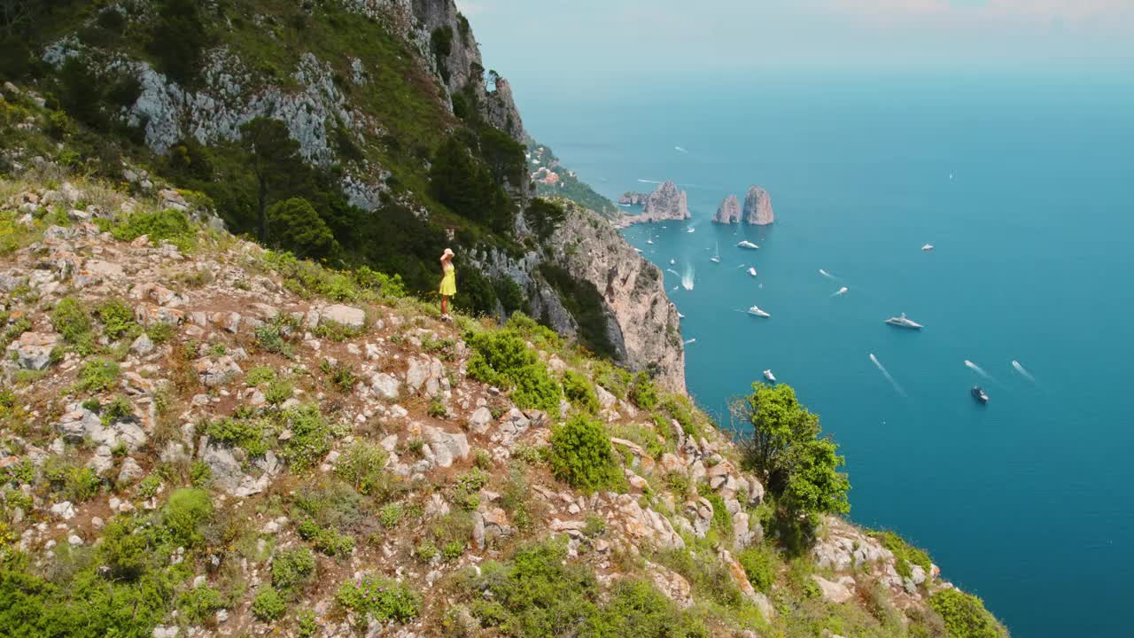 游客在山上徒步旅行，欣赏着卡普里岛的美景，那里有多岩石的海岸线。欣赏大海全景的女人。视频素材