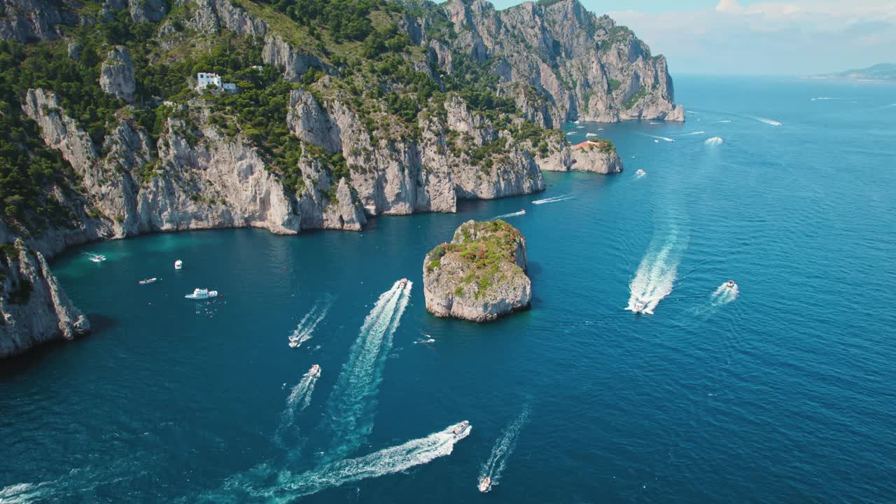 卡普里岛海滨有漂浮的游艇。动态水景，船只巡游标志性的法拉格里奥尼岩层。意大利著名的旅游胜地。视频素材