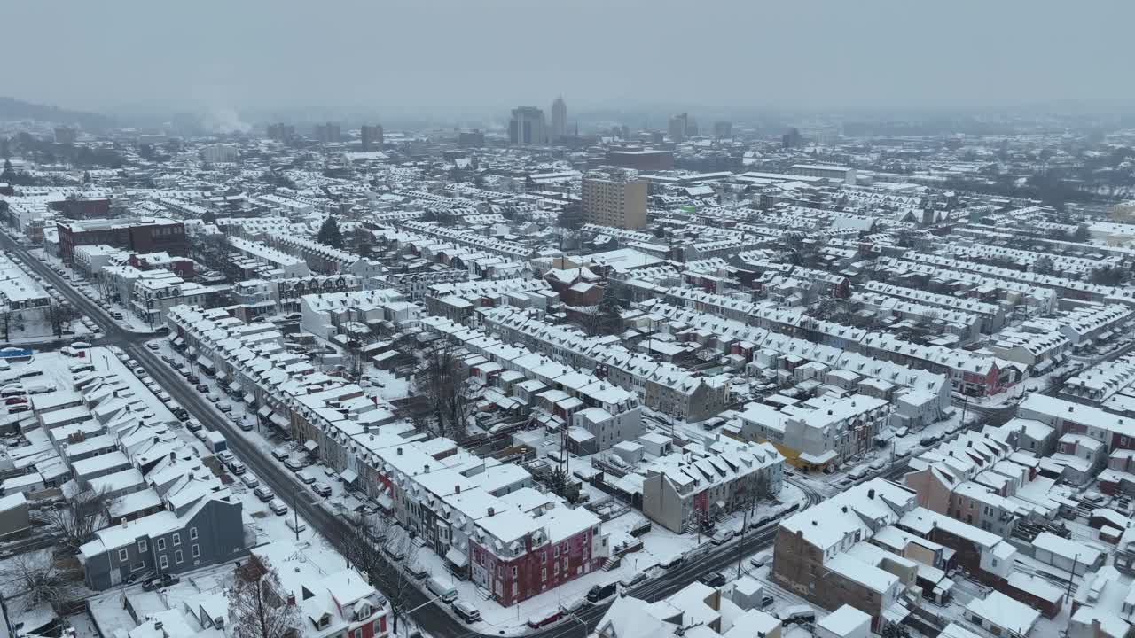 冬季，美国小镇被雪覆盖。阴天的一排房子。无人机向前飞行。视频素材