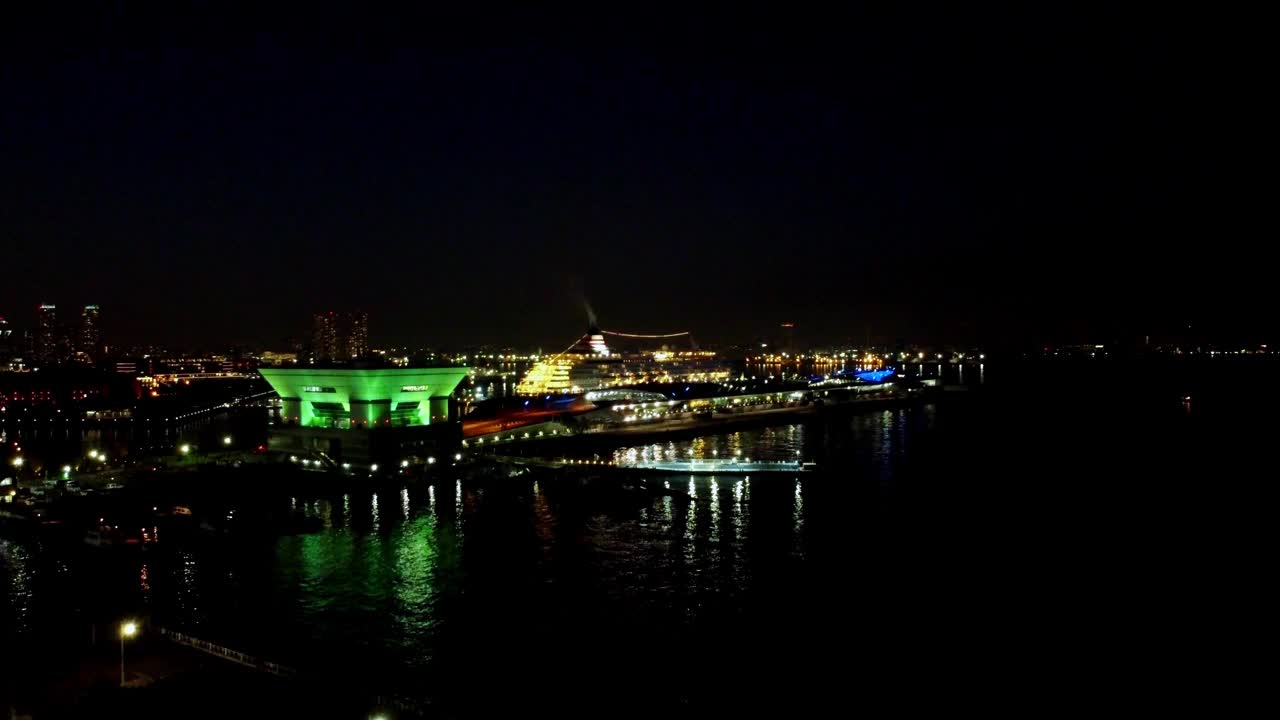 夜景的城市天际线与照明建筑反映在水面上，充满活力，高角度视频素材