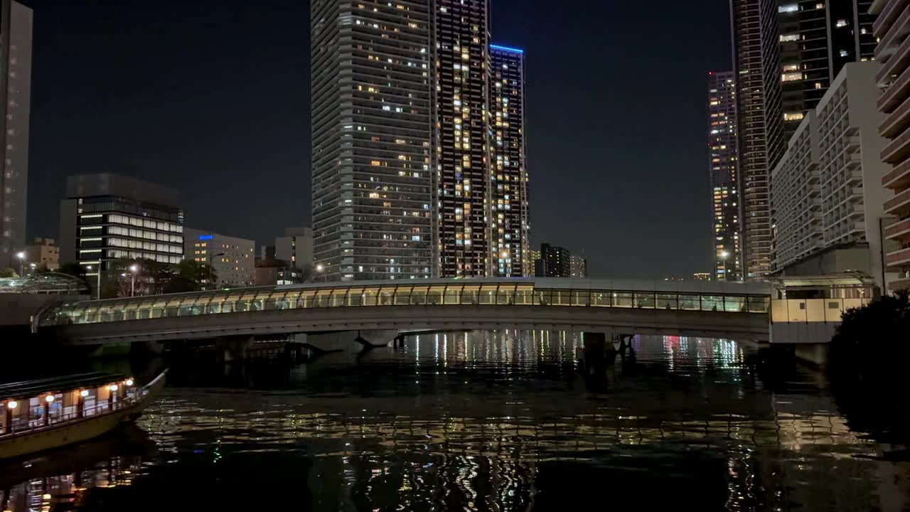 夜景，灯火通明的建筑和倒影在水面上的桥梁，宁静的城市景象视频素材