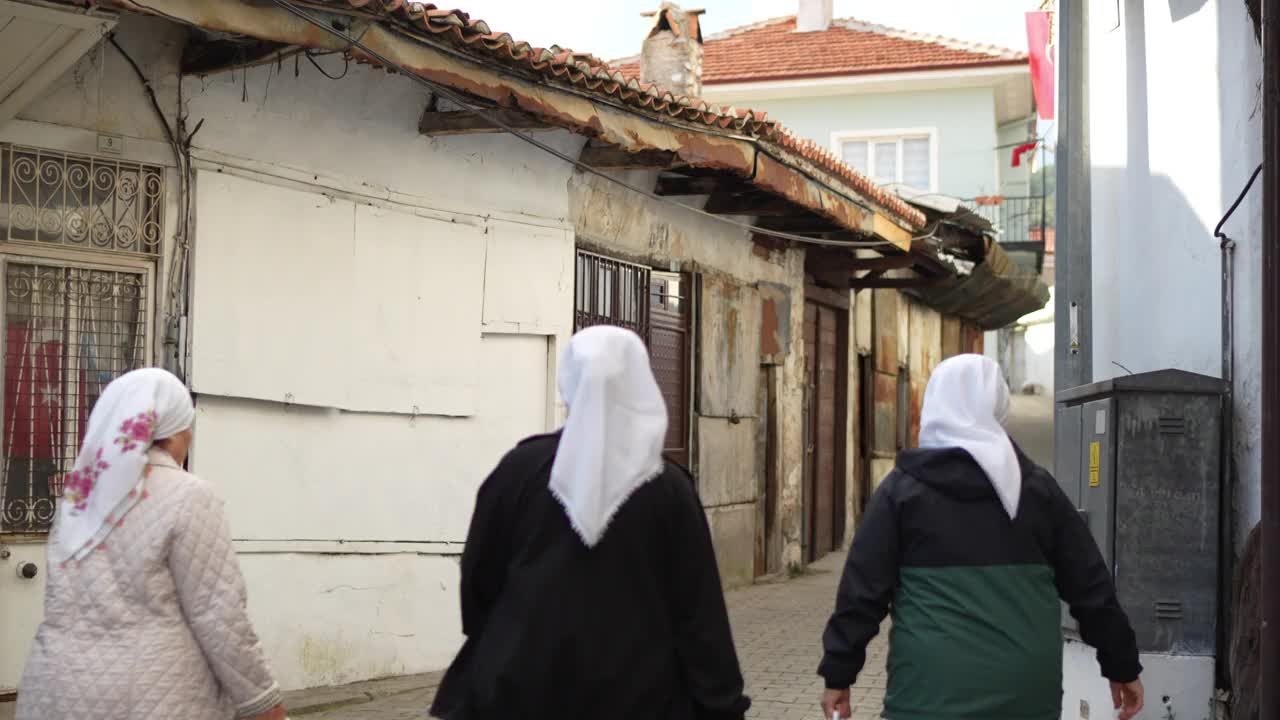 Old Muğla大街上戴着头巾的妇女带着从面包店买来的皮塔饼回家视频下载