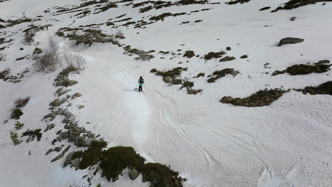 鸟瞰滑雪自由式滑雪者在雪山的高处在朋友的陪伴下下坡视频素材