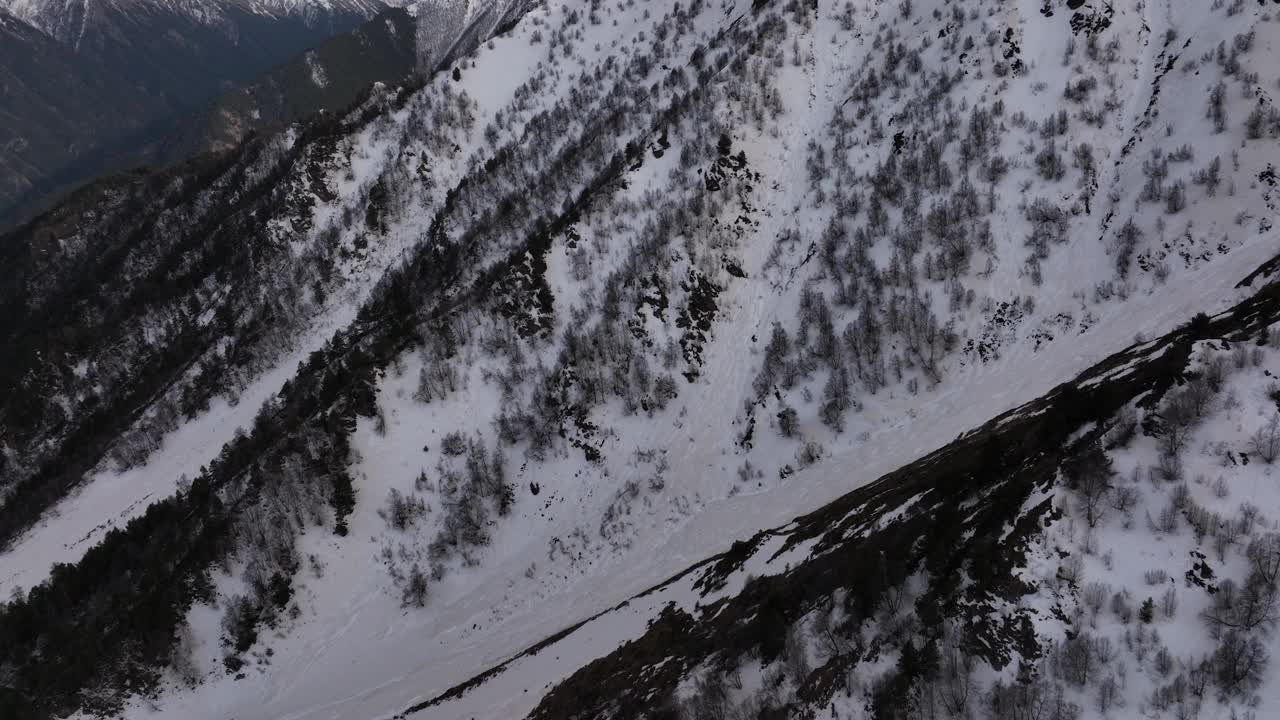 从无人机到长焦镜头的鸟瞰图，多维度的山脉、岩石和山脊。白雪覆盖的山峰在山上的岩石。冬季史诗视频背景视频素材