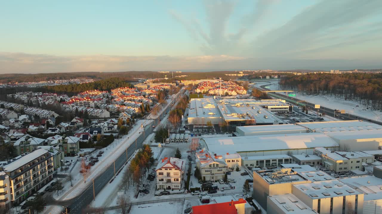 波兰城市郊区冬天的金色日出。背景是积雪覆盖的工厂屋顶和住宅区。航拍鸟瞰图。视频素材