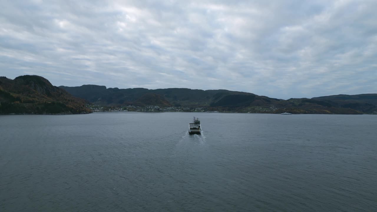 一艘渡船驶过尼斯维克附近平静的水域，背景是海地，多云的天空，鸟瞰图视频素材