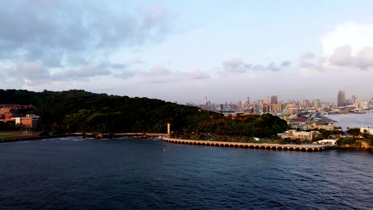 海边葱郁的山坡，日落时的城市天际线，鸟瞰图视频素材