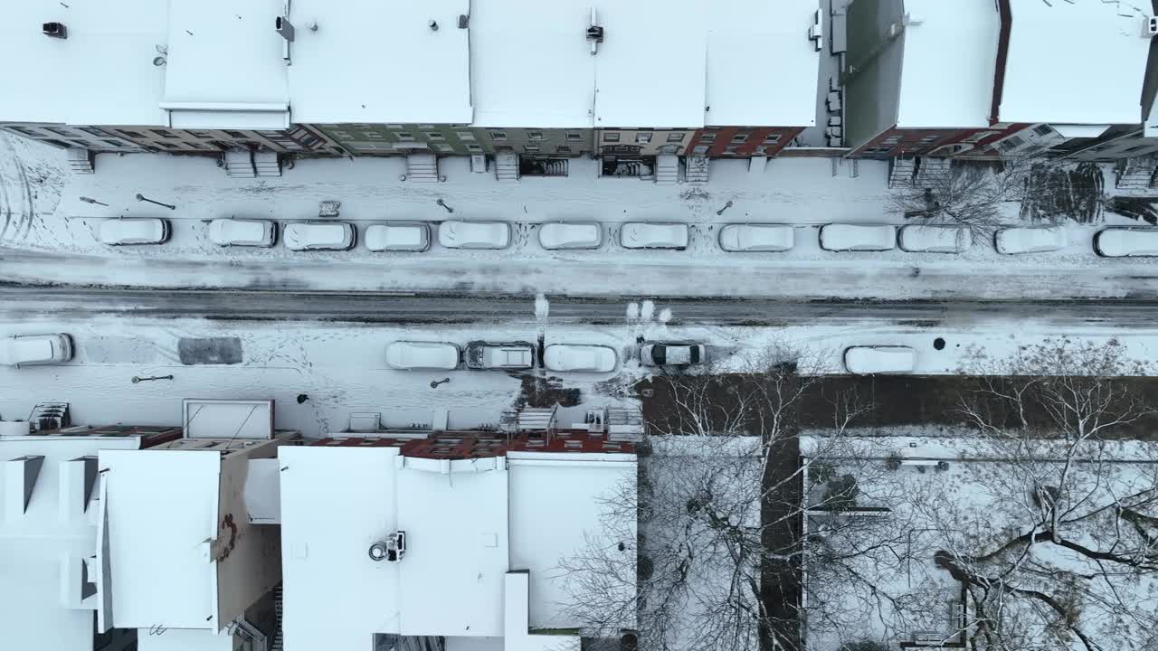 美国城镇街道上被雪覆盖的汽车、房屋和建筑物。空中俯视立交桥。视频素材