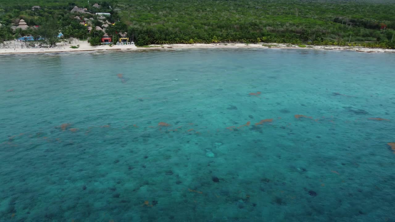 科苏梅尔海岸线上清澈的绿松石般的海水，郁郁葱葱的绿色植物和船只视频素材